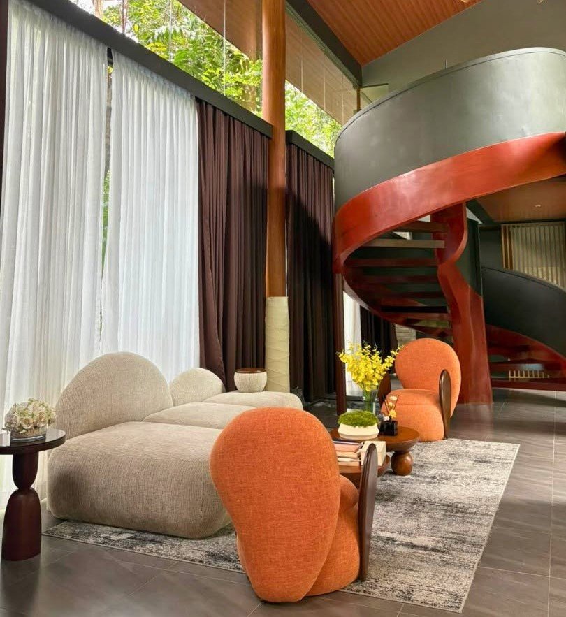 Living area with a spiral staircase and orange lounge chairs
